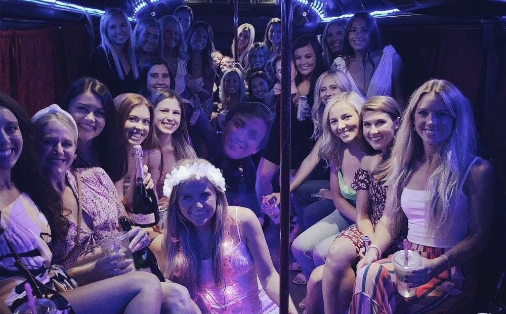 A group of women are posing for a picture on a bus.
